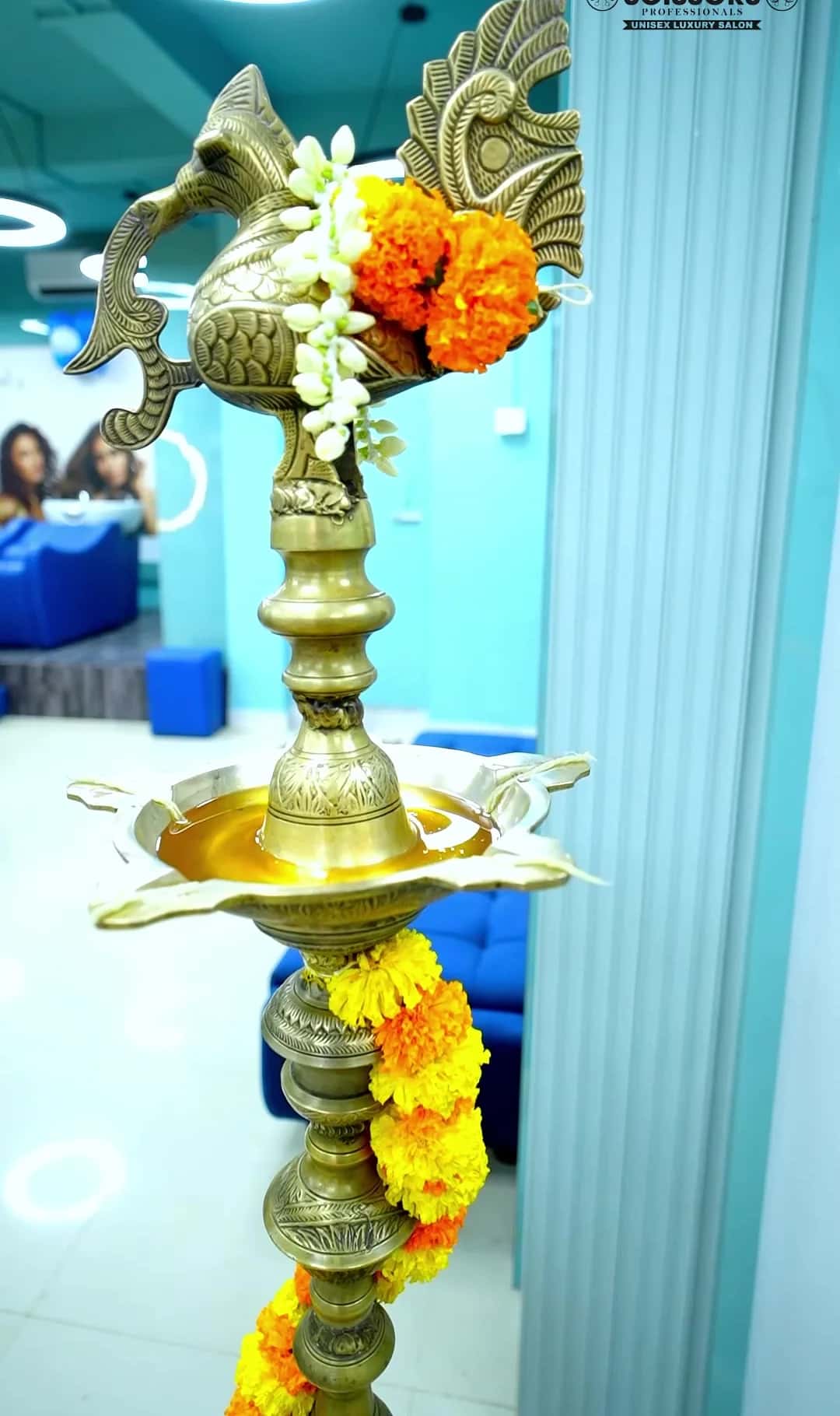 Traditional brass lamp decorated with marigold garlands at the salon entrance