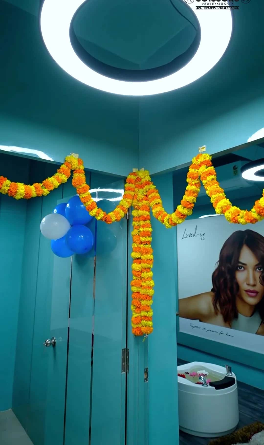 Marigold garland and blue balloons at the interior glass door with ring pendant light above