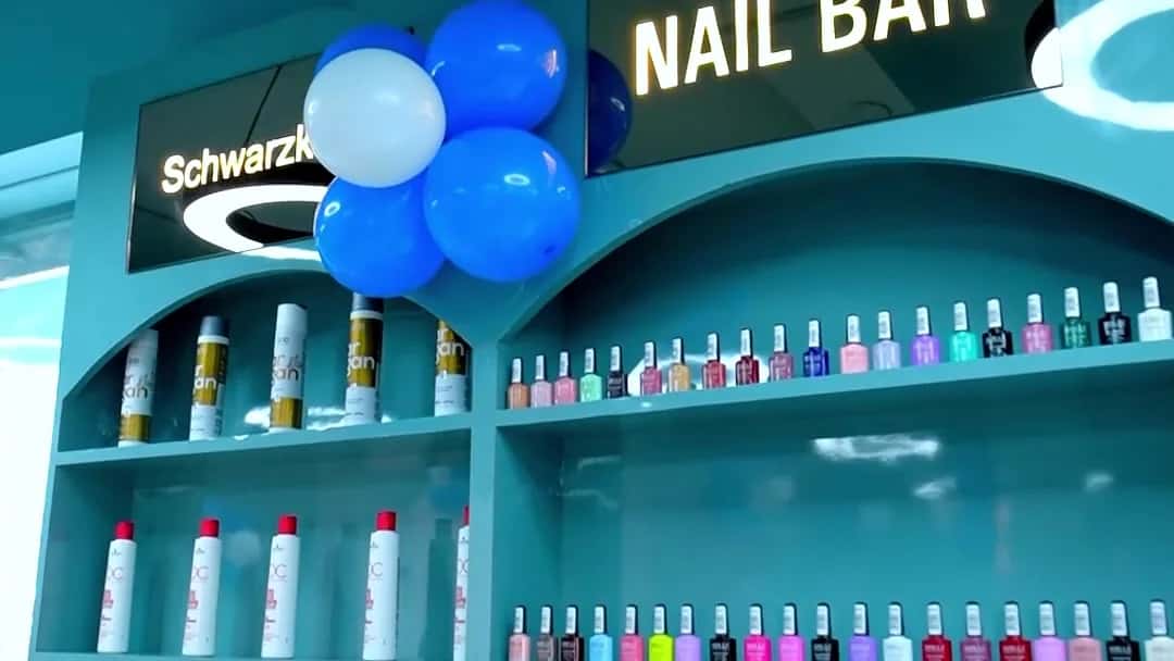 Nail Bar with teal arched shelving holding nail polish bottles and Schwarzkopf Professional products