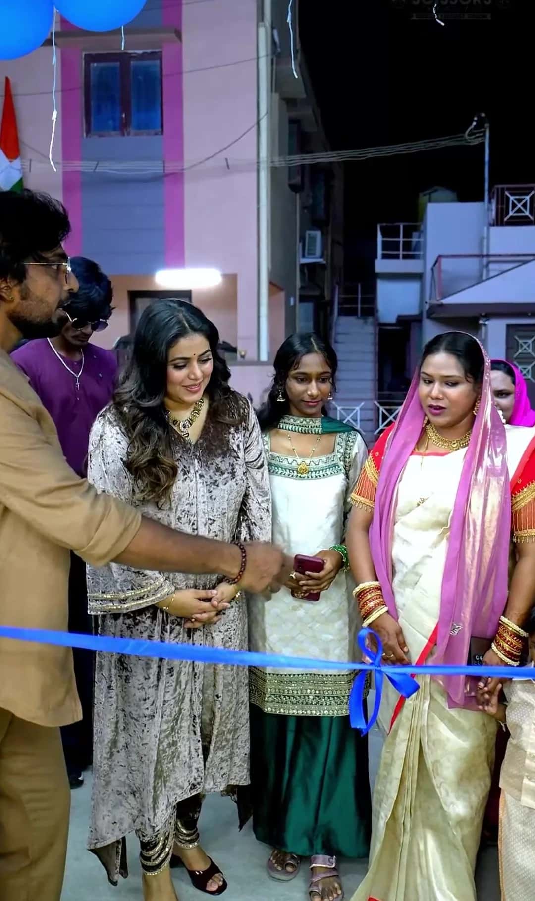 Guest lighting the traditional lamp at the salon grand opening, with marigold garland