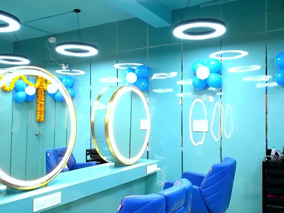 Styling station with a gold ring mirror, royal blue chair and ring pendant lights under a teal ceiling