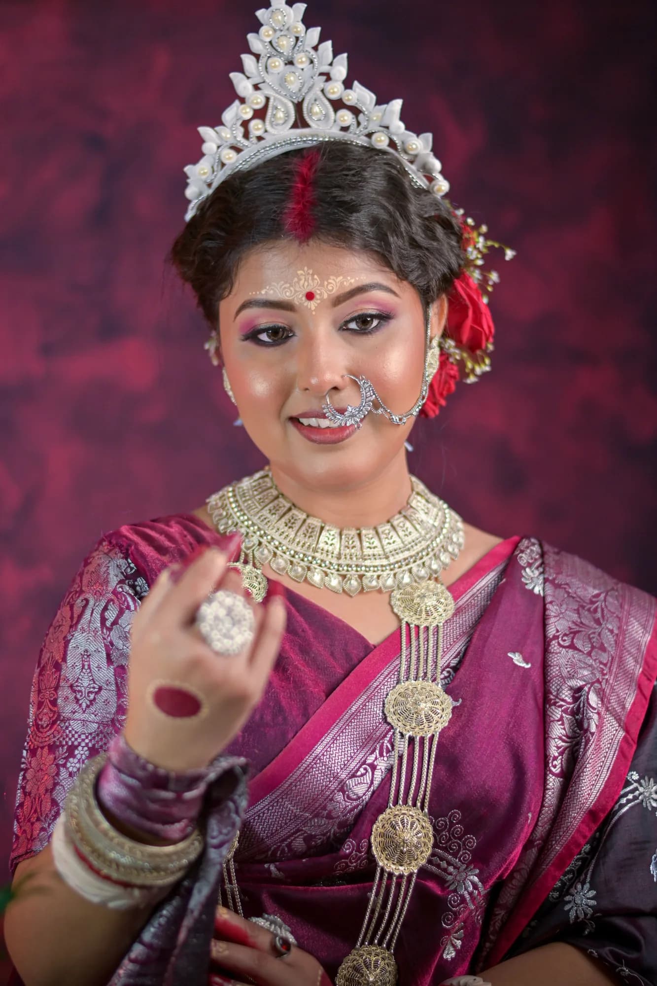Bride wearing a silver crown, gold necklace and traditional bridal makeup