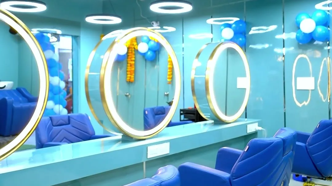 Gold ring mirrors, royal blue styling chairs and ring pendant lights across the salon floor
