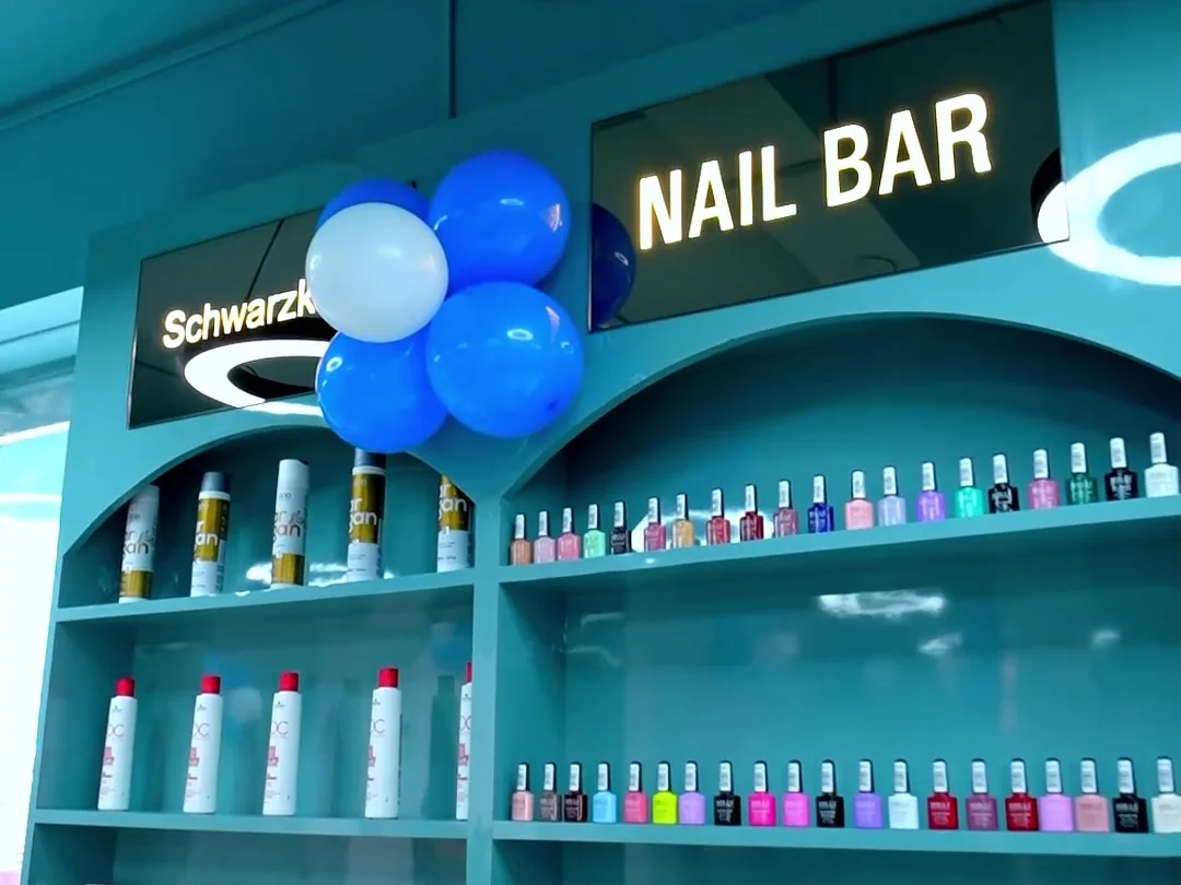Nail Bar with teal arched shelving holding nail polish bottles and Schwarzkopf Professional products